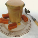 Toffee-Karamellsoße in einem Glas mit Toffee-Bonbons im Vordergrund.