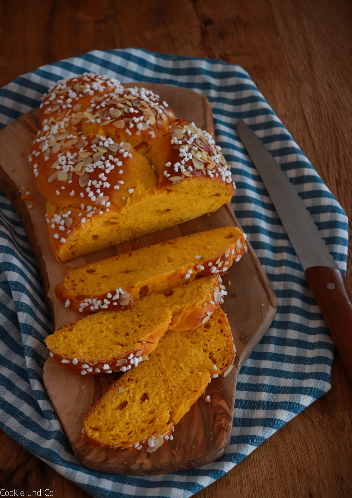 Saftiger Kürbis-Hefezopf mit lockerer Krume bestreut mit Hagelzucker und gehobelten Mandeln. 