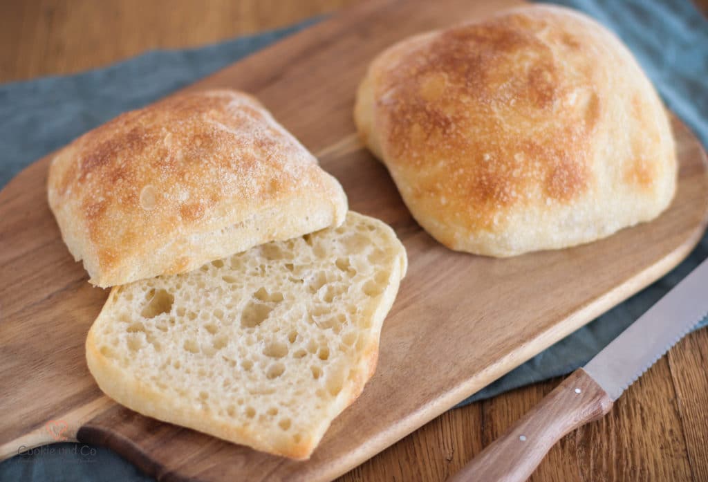 Panini Semplici - einfache Coabatt-Brötchen auf einem Holzbrett. 