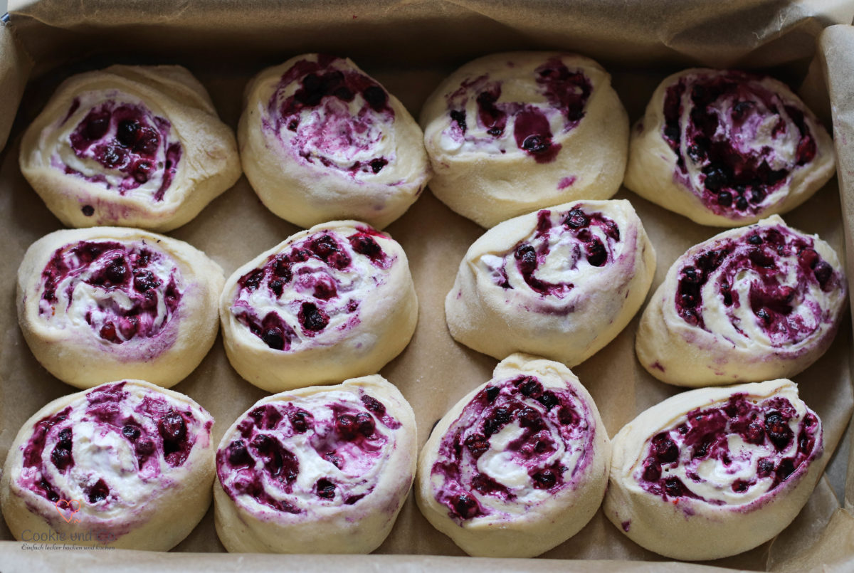 Saftige Hefeschnecken mit Blaubeeren frisch gebacken in der Backform vor dem Backen.