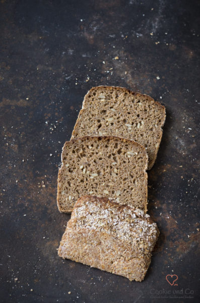 Kerniges Vollkornbrot in Scheiben auf einem alten Backblech.