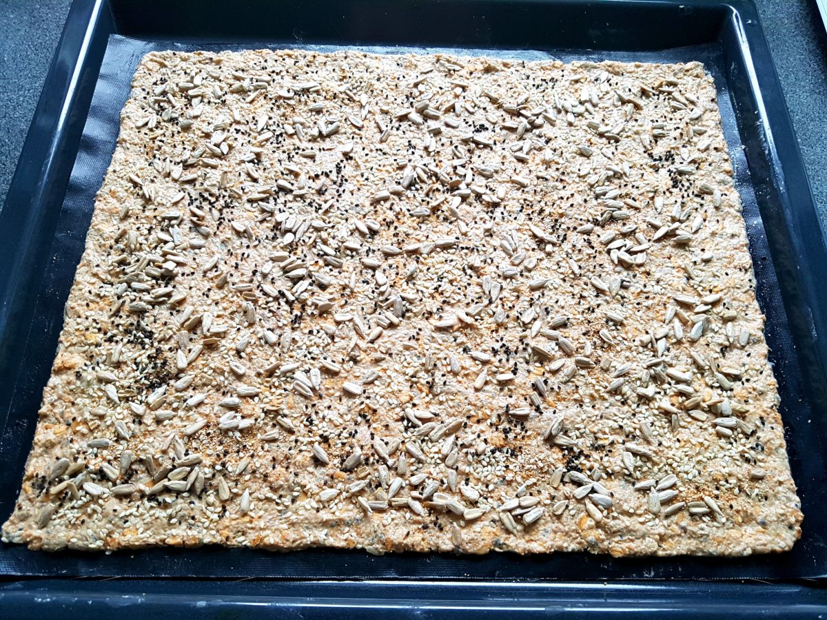 Teig für selbstgemachtes Knäckebrot auf einem Backblech