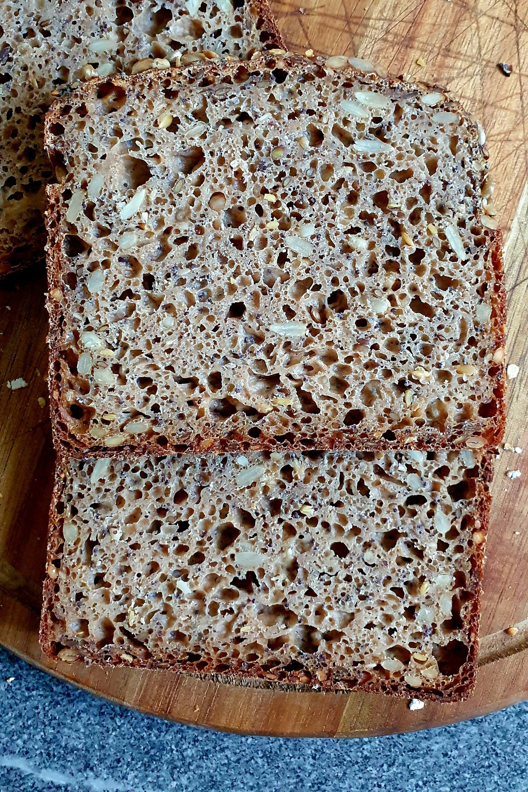 Dinkel-Saatling mit Sauerteig in Scheiben geschnitten auf einem Holzbrett.