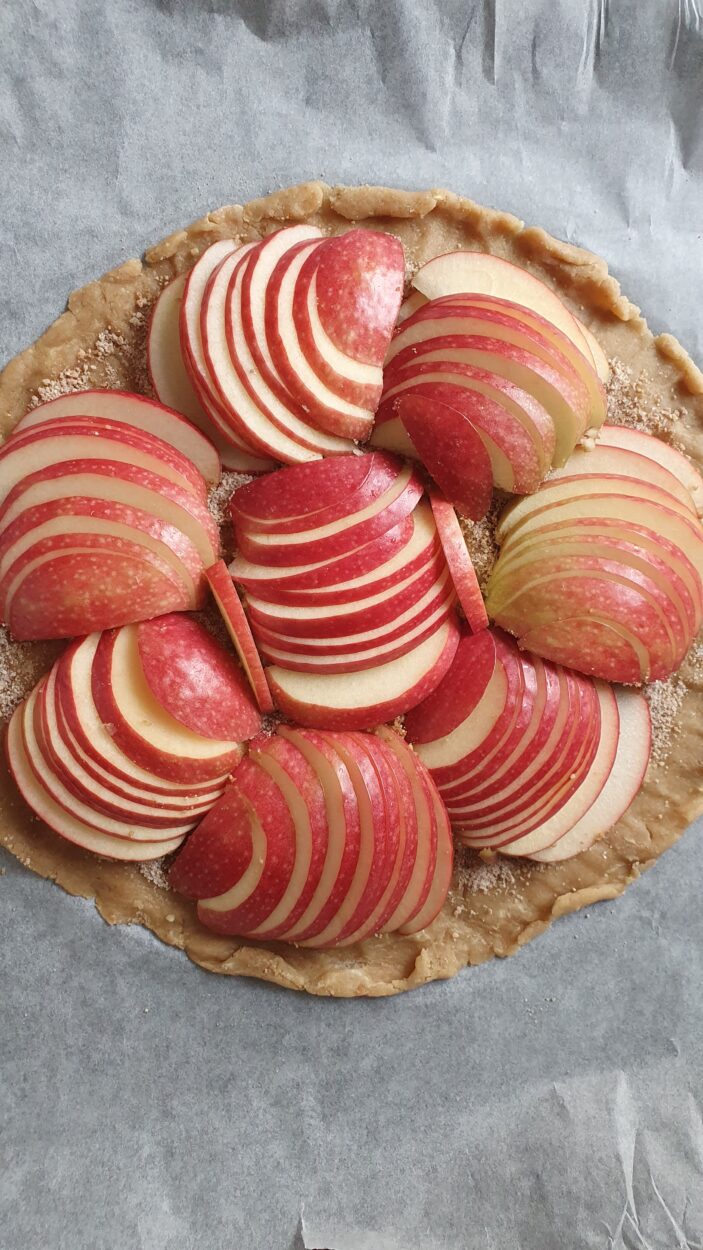 Mit Äpfeln belegter Mürbeteig für eine Apfelgalette.