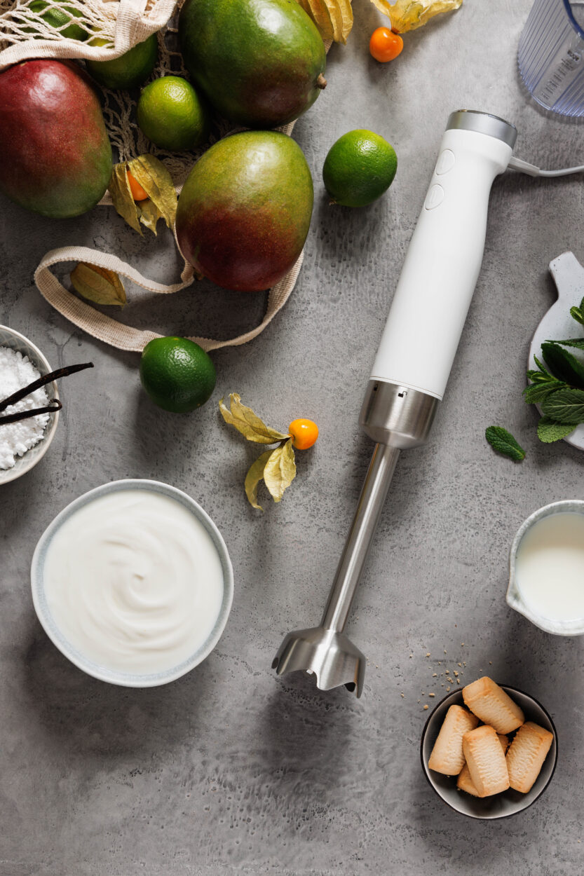 Zutaten für ein Mango-Dessert mit Joghurt und ein Pürierstab.