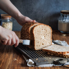 Hafer-Joghurt-Brot auf einem Holzbrett, das in Scheiben geschnitten wird.