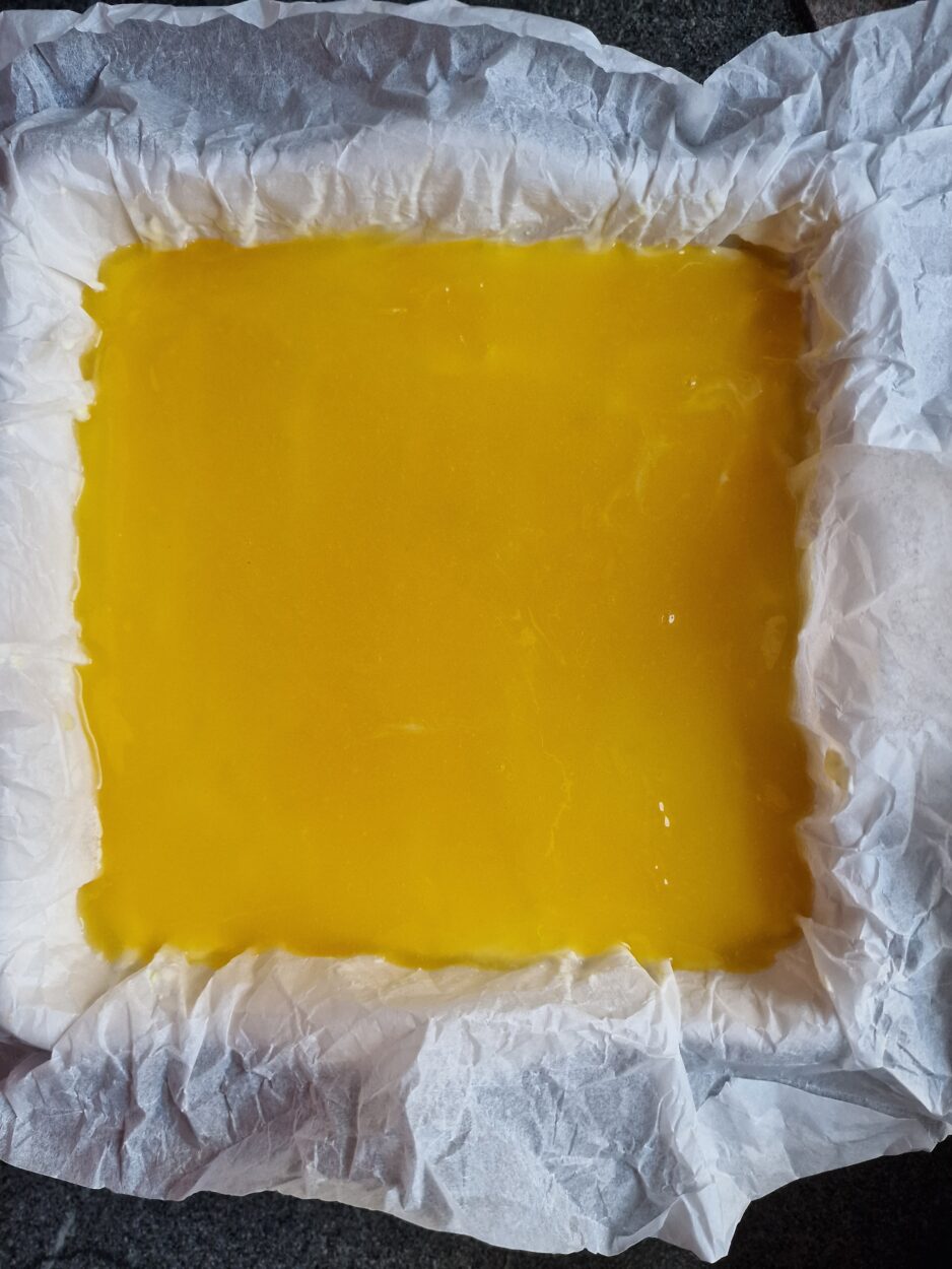 Fertiger Lemon Cheescake in der Kuchenform mit Backpapier vor dem Kaltstellen.