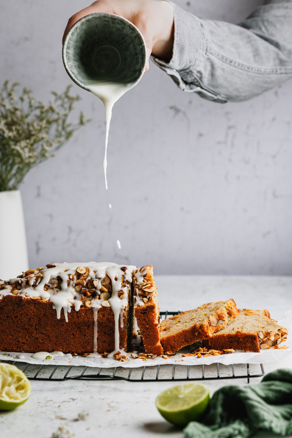 Zucchinikuchen mit Nüssen auf einem Kuchengitter, auf den Zuckerguss gegossen wird.