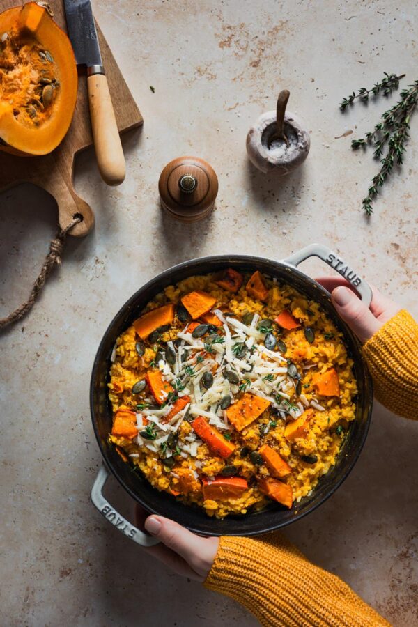 Kürbisrisotto aus dem Ofen mit Parmesankäse, Kürbiskernen und Thymian.