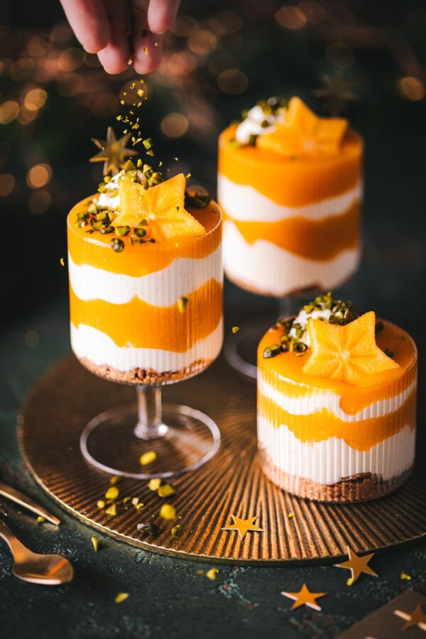 Weihnachtliches Kaki-Schichtdessert mit Joghurt-Creme und Kaki-Soße getoppt mit Pistazien. 