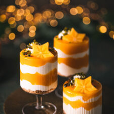 Weihnachtliches Kaki-Schichtdessert mit Joghurt-Creme und Kaki-Soße getoppt mit Pistazien.