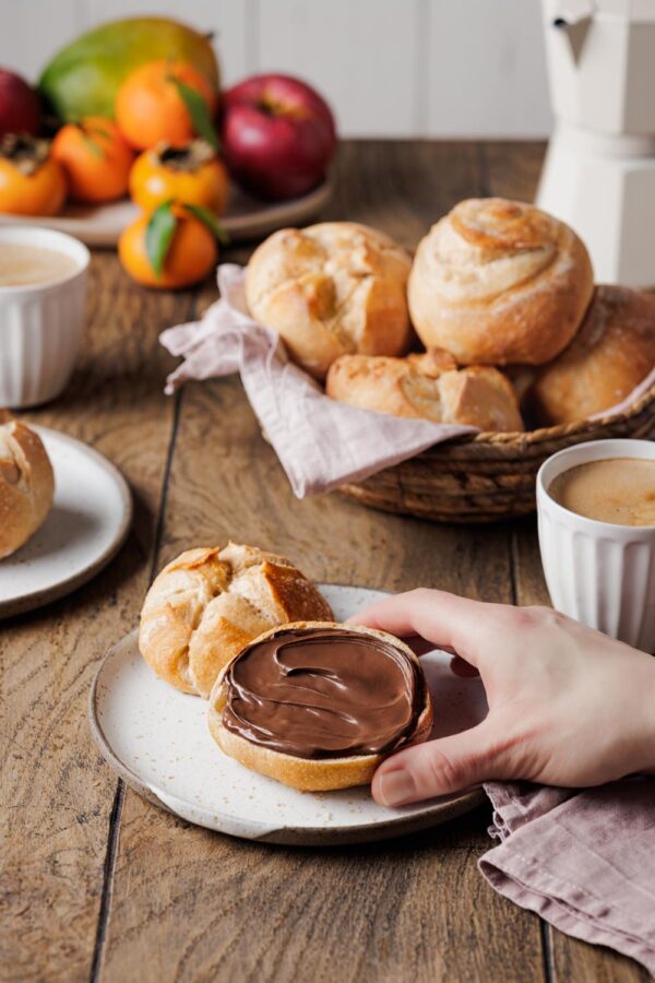 Goldkuller mit Nuss-Nugat-Crene auf einem gedeckten Frühstückstisch.
